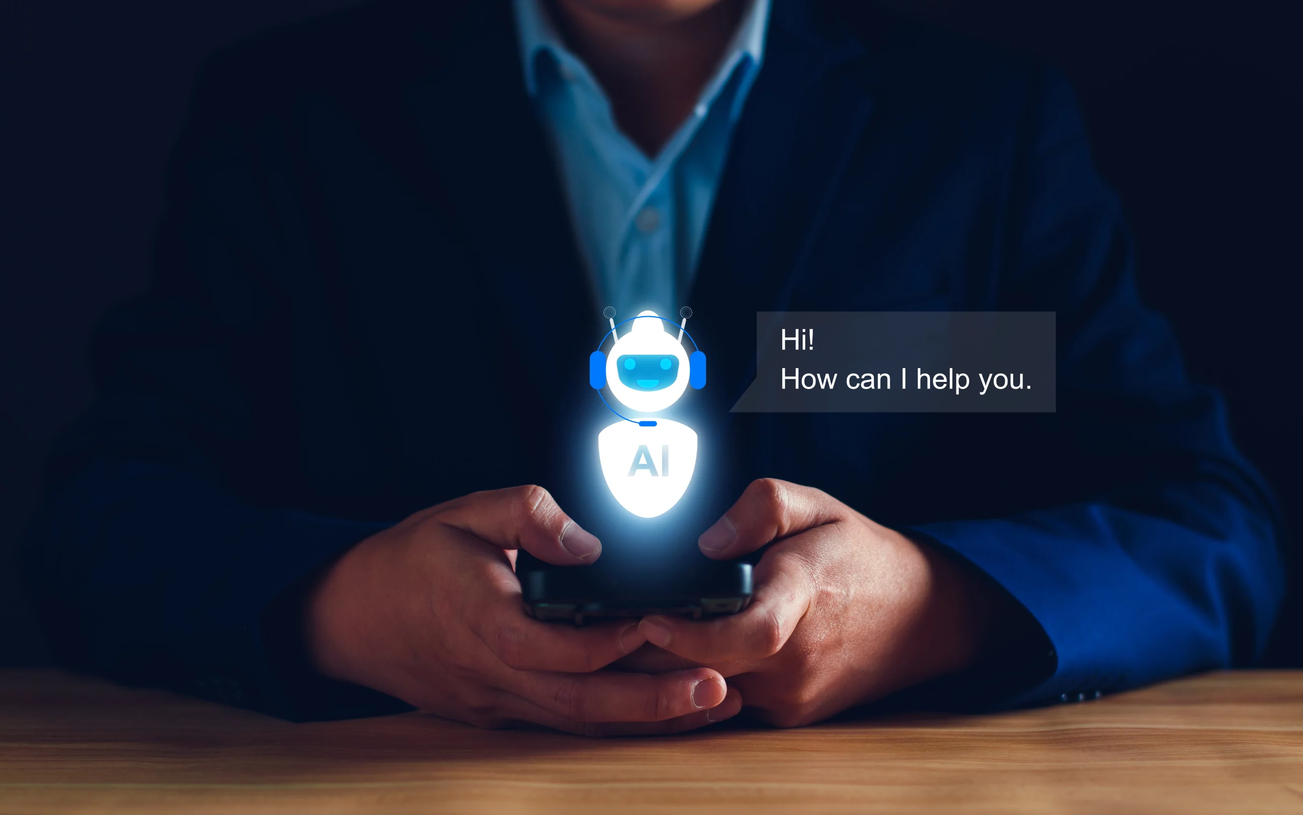 Kuvassa henkilö pitelee älypuhelinta, josta heijastuu digitaalinen myyntiassistentti. Näytöllä näkyy hymyilevä tekoälyrobotti ja tekstiviesti 'Hi! How can I help you.'.